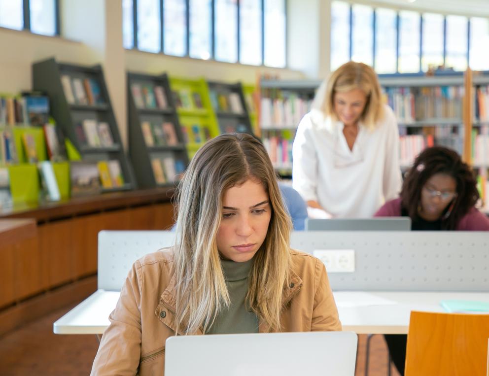 A student in the library studying with her laptop